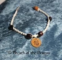 kanji Happiness symbol on small wooden charm hanging from wooden beaded macramé choker necklace