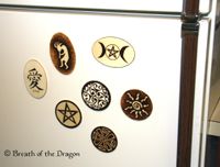 multiple wooden magnets (oval, circle, rectangle) on a white fridge door