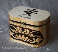 wooden box with rounded corners featuring lotus design on front and kanji symbol Tranquility on lid, pyrography by Sunfire