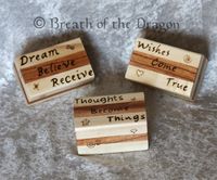 3 small striped boxes featuring symbols and phrases such as 'Thoughts Become Things'